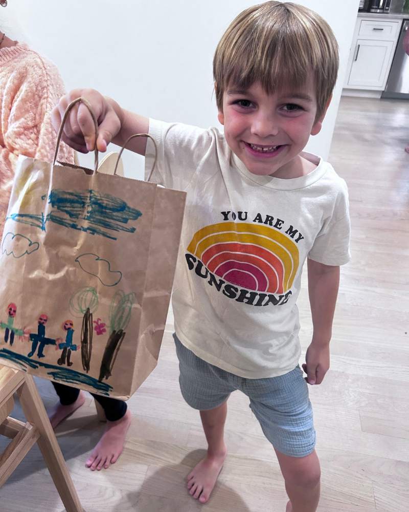 Young boy holding up kid's bag